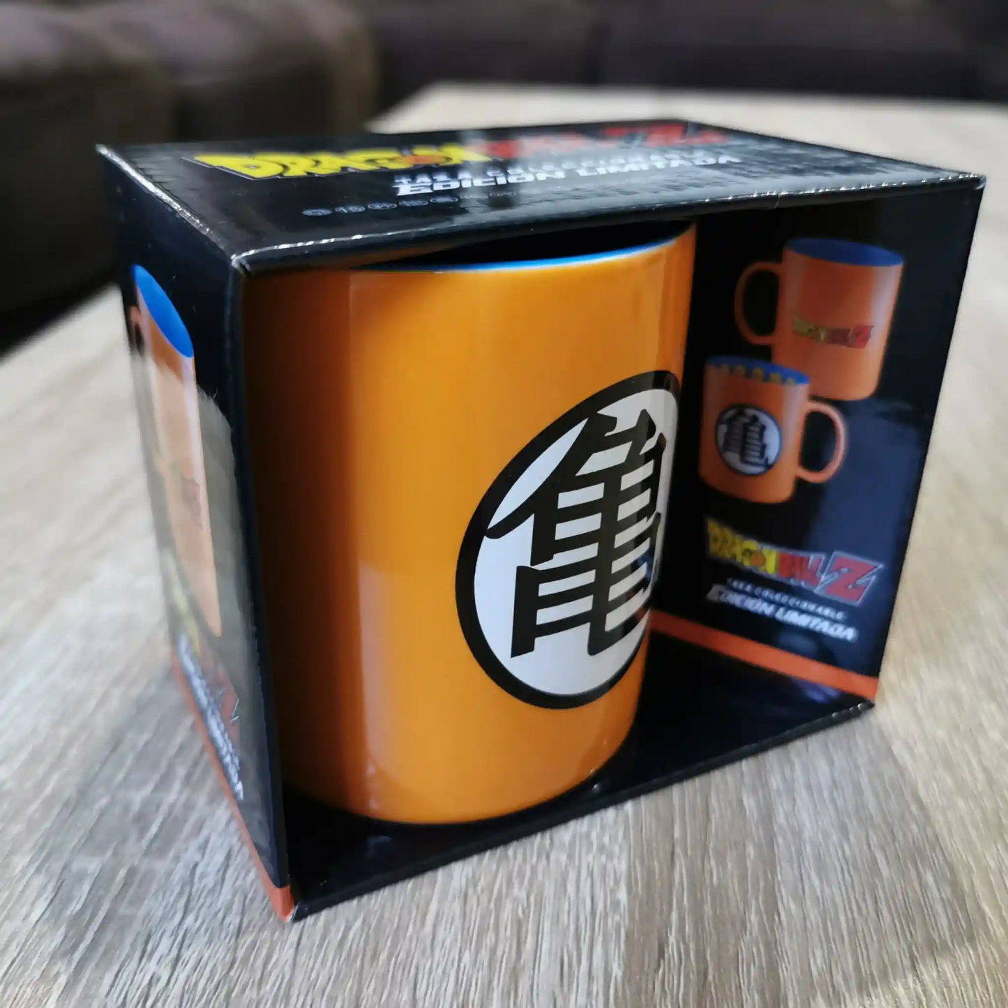 Taza de Dragon Ball Z en empaque original, colocada sobre una mesa de madera