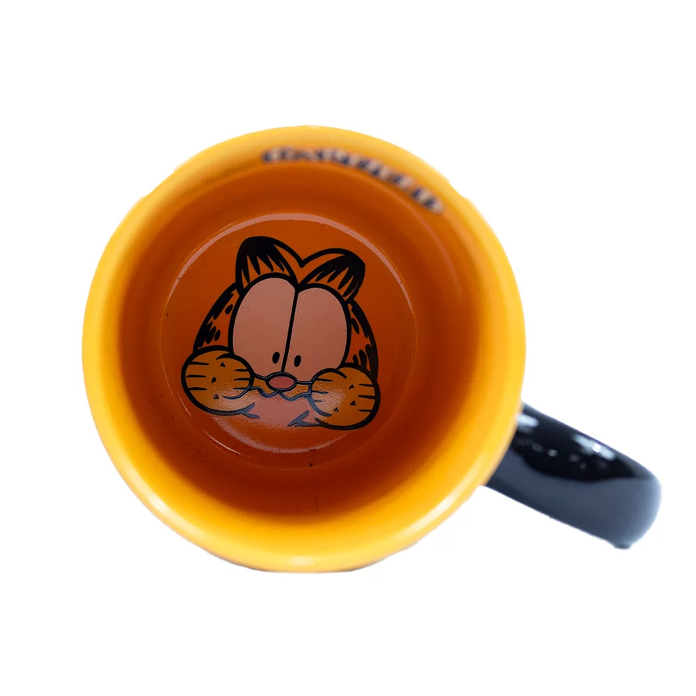 Vista superior de la taza de Garfield mostrando el interior naranja con el rostro de Garfield en el fondo.