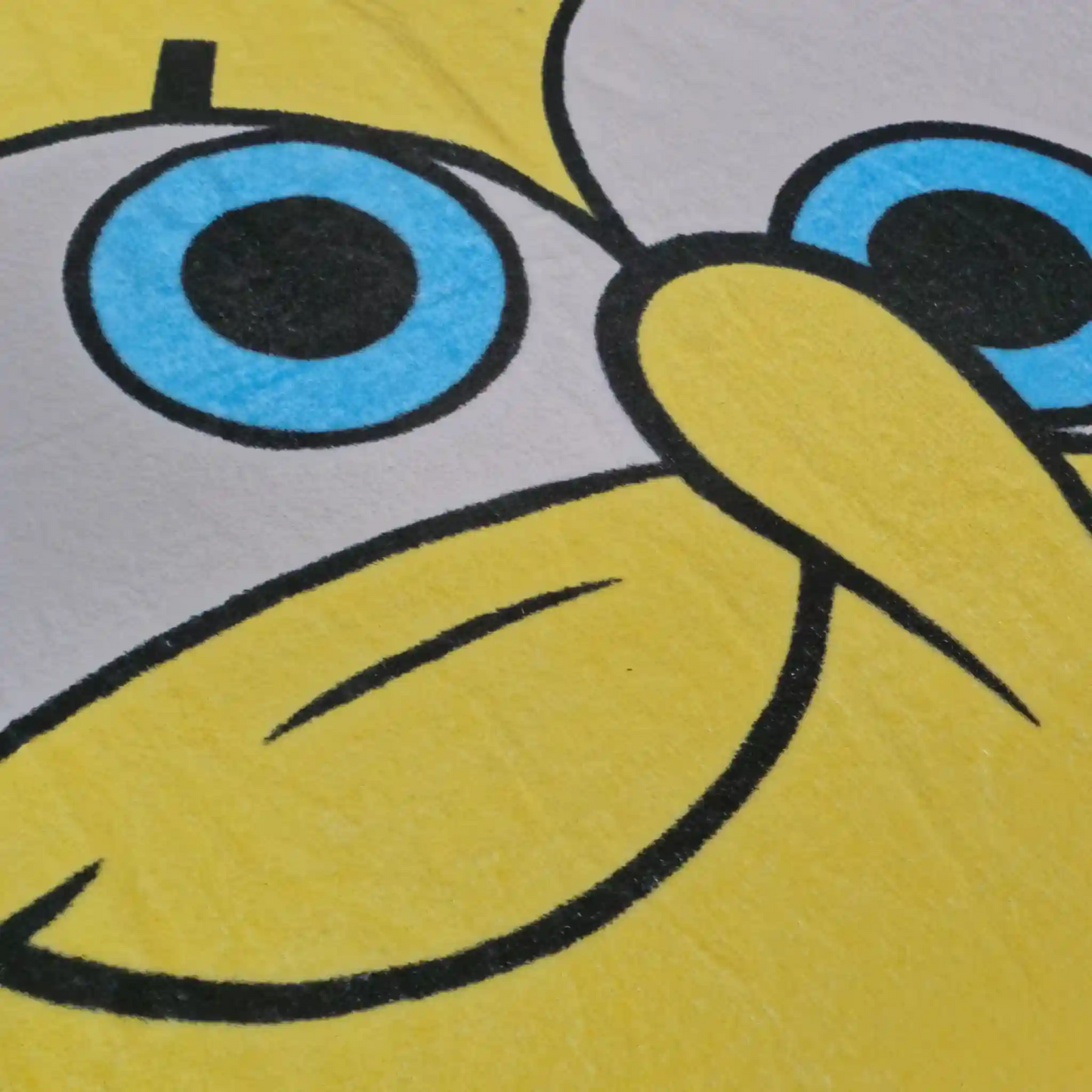 Acercamiento al rostro de Bob Esponja impreso en cobija polar con colores vibrantes