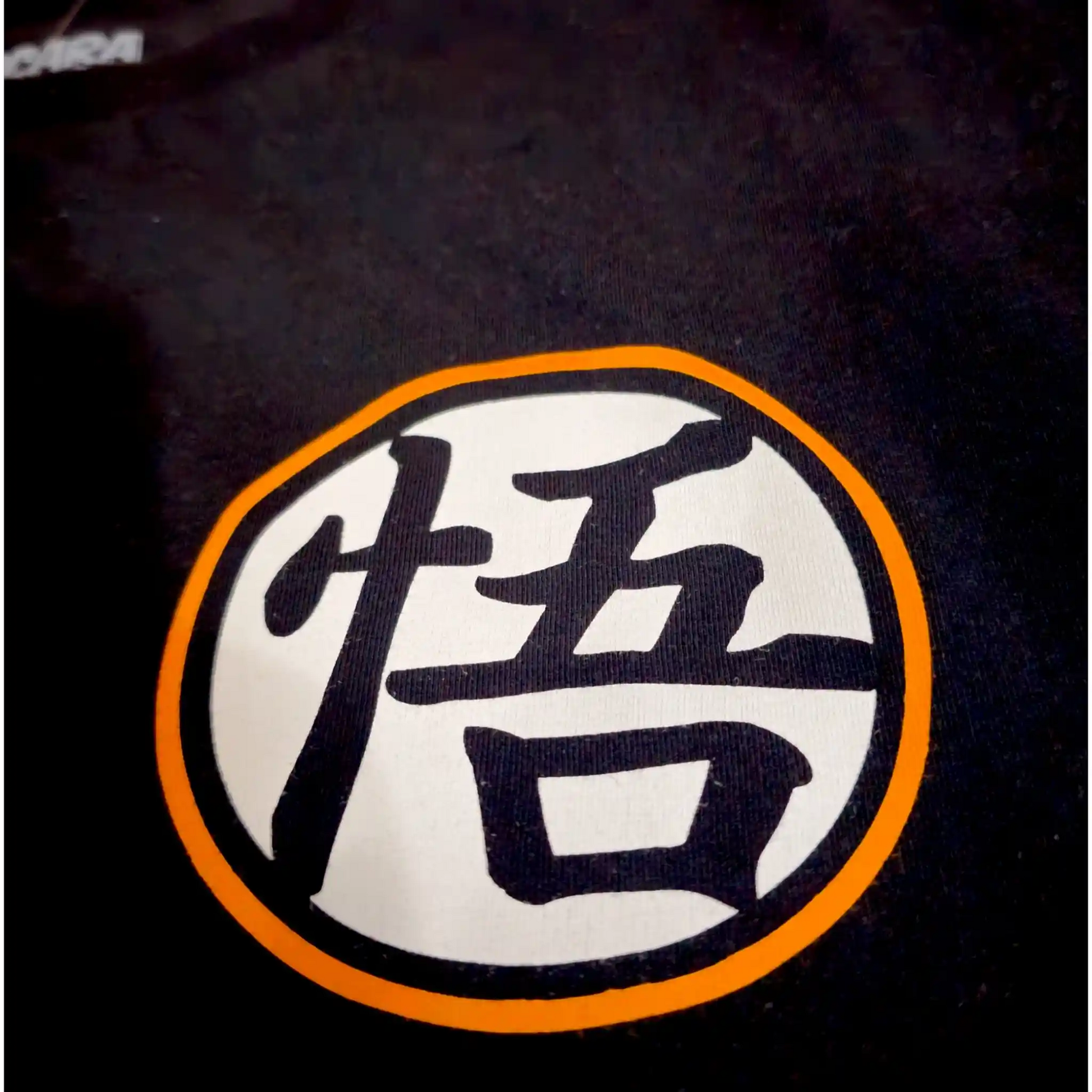 Detalle del símbolo kanji de Goku estampado en el pecho de la playera oversize negra de Dragon Ball
