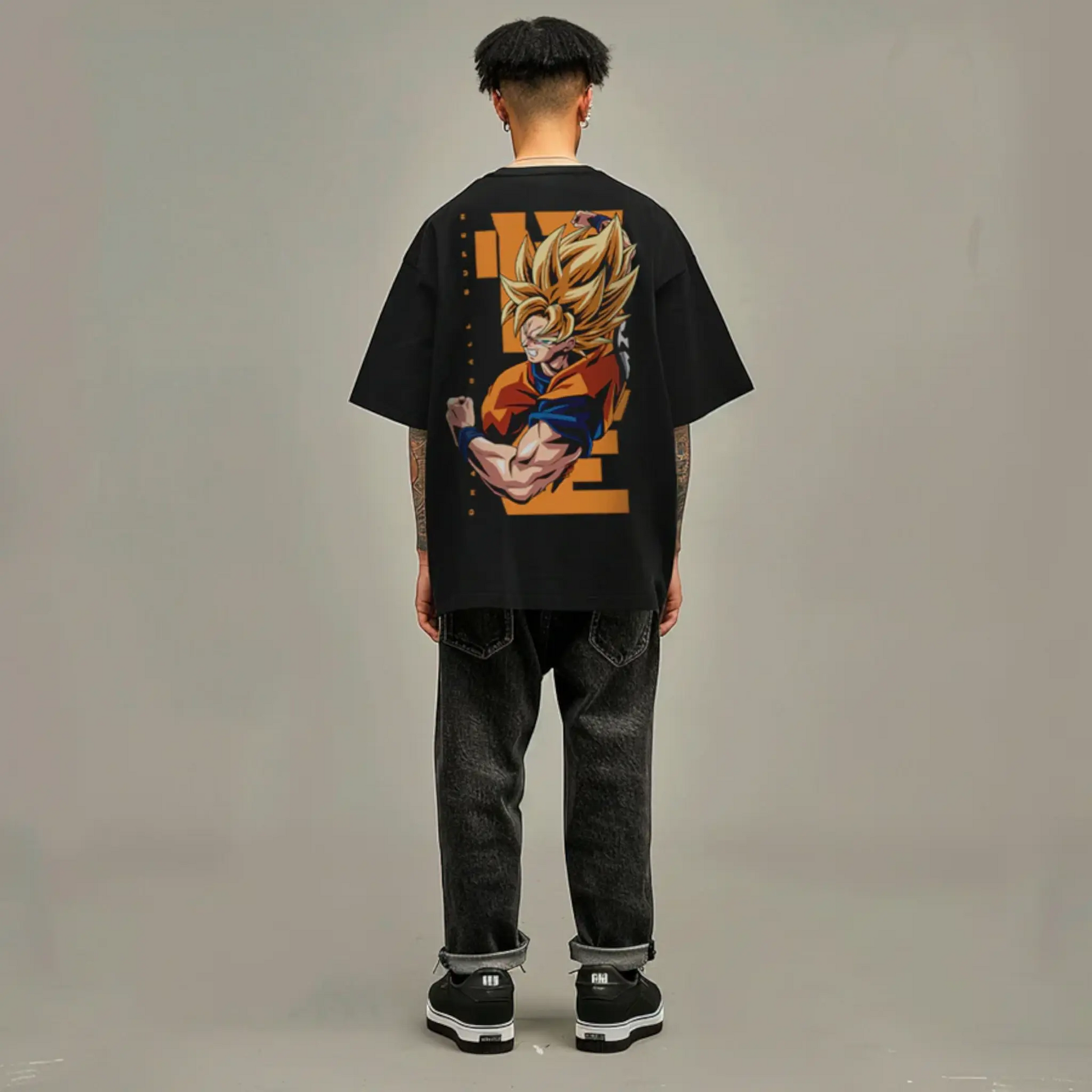 Modelo con playera oversize negra con Goku Super Saiyajin 2 en la espalda, diseño oficial de Dragon Ball