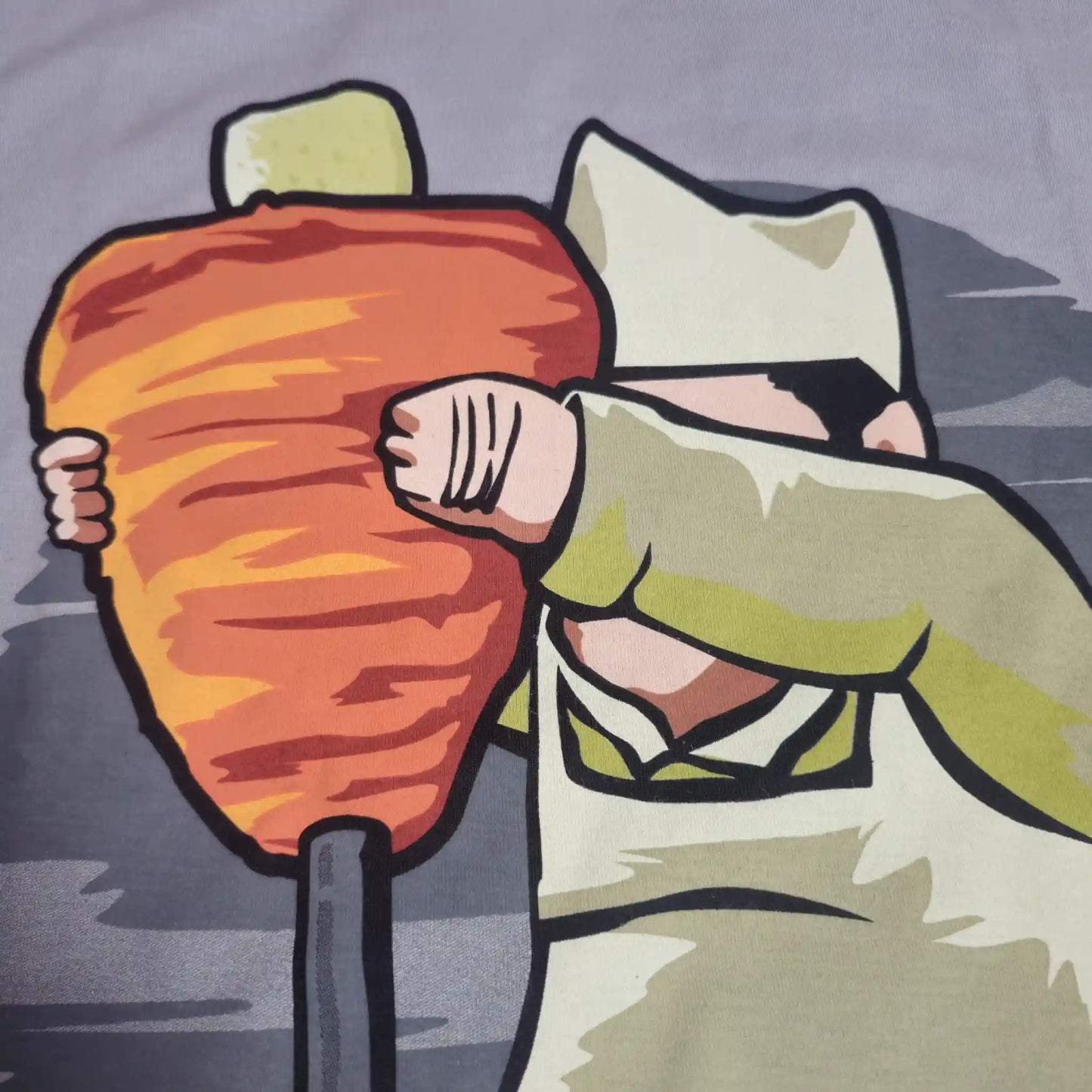 Detalle del diseño en la playera de taquero abrazando un trompo de pastor estilo dibujo animado