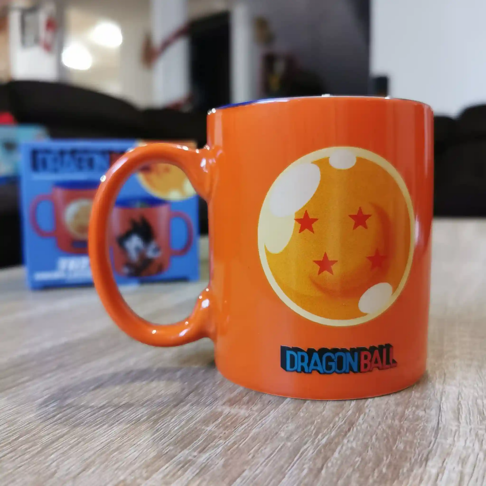 Taza de Dragon Ball colocada sobre una mesa, con ilustración de la esfera del dragón de cuatro estrellas