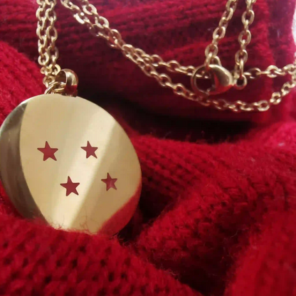 Dije dorado con 4 estrellas rojas inspirado en Dragon Ball Z sobre tela tejida roja