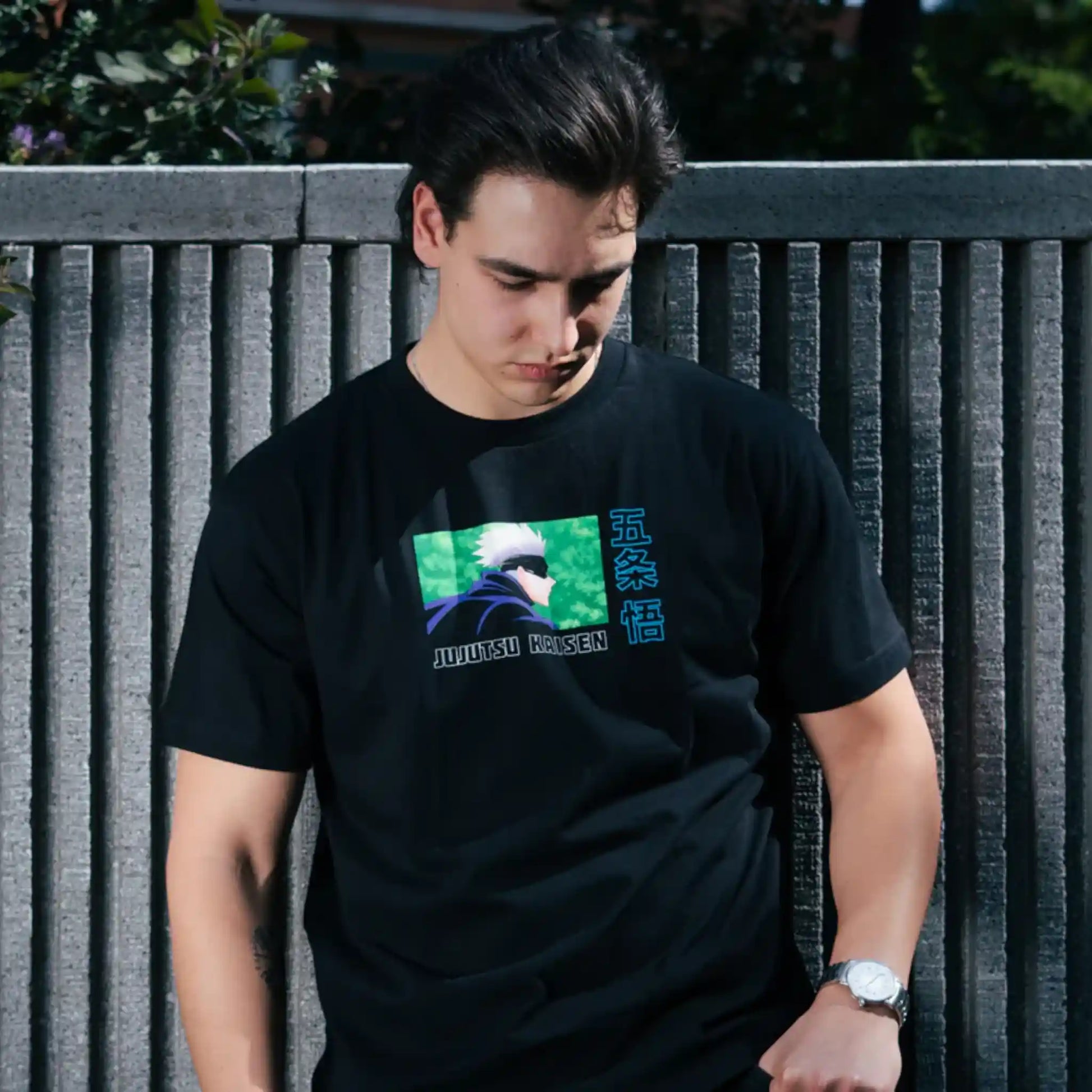 Modelo usando playera oversize negra de Gojo Satoru de Jujutsu Kaisen con diseño minimalista en el pecho, posando al aire libre